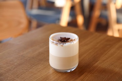 Photo of Glass of aromatic coffee on wooden table in cafe, closeup