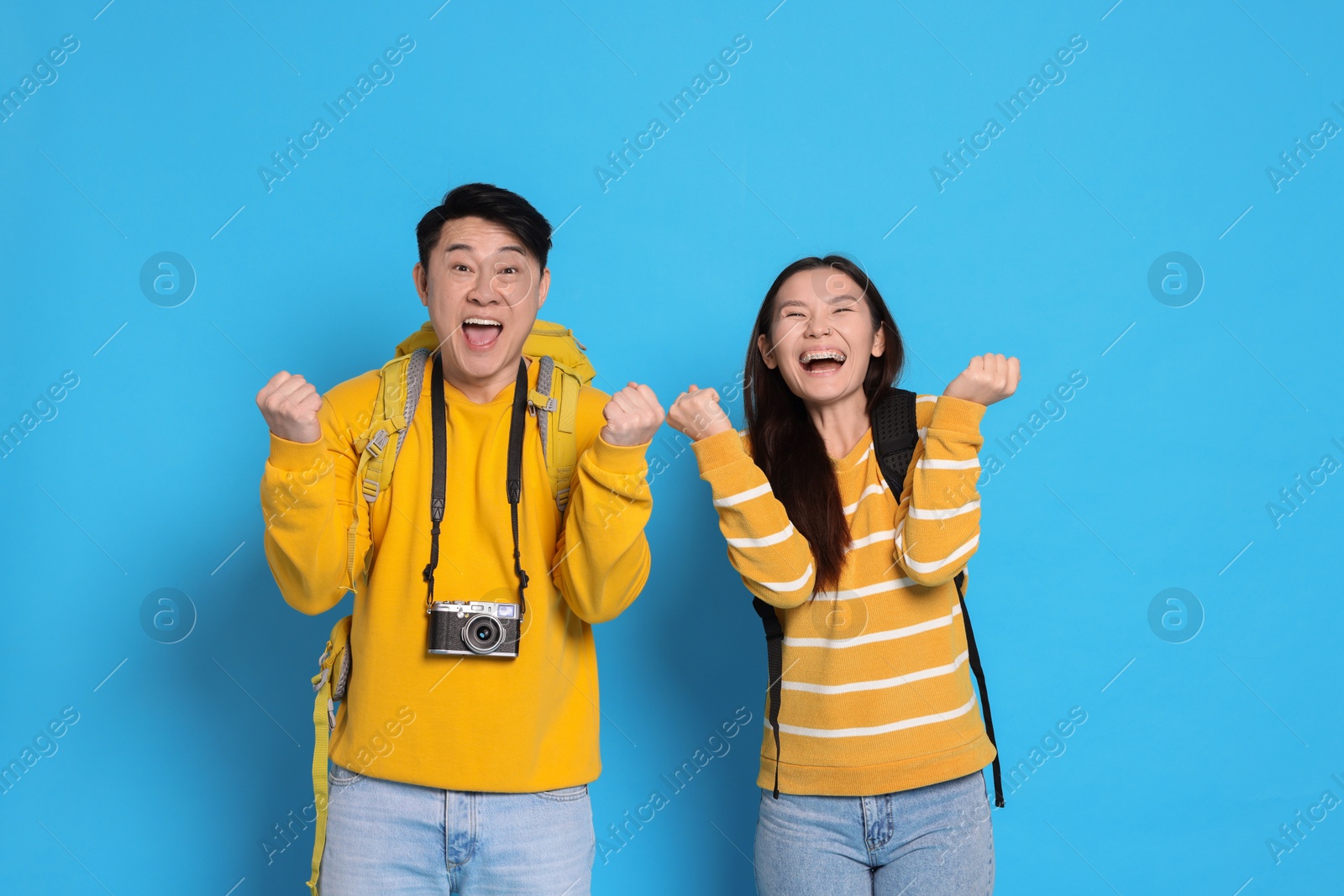 Photo of Couple of excited travellers on light blue background