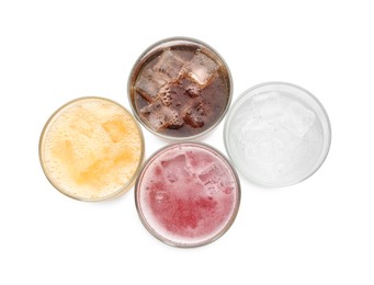 Photo of Soda water of different flavors with ice cubes in glasses isolated on white, top view