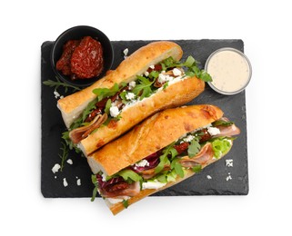 Photo of Halves of baguette sandwich with prosciutto and sun dried tomatoes isolated on white, top view