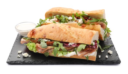 Photo of Halves of baguette sandwich with prosciutto and sun dried tomatoes isolated on white