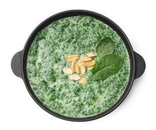 Photo of Delicious spinach sauce with peanuts in frying pan isolated on white, top view