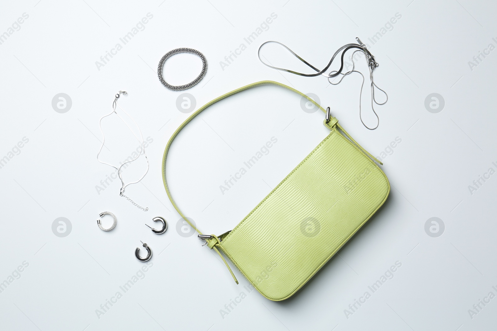 Photo of Beautiful bag and stylish accessories on white background, flat lay