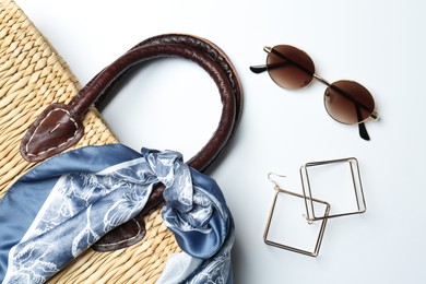 Photo of Wicker bag and stylish accessories on white background, flat lay