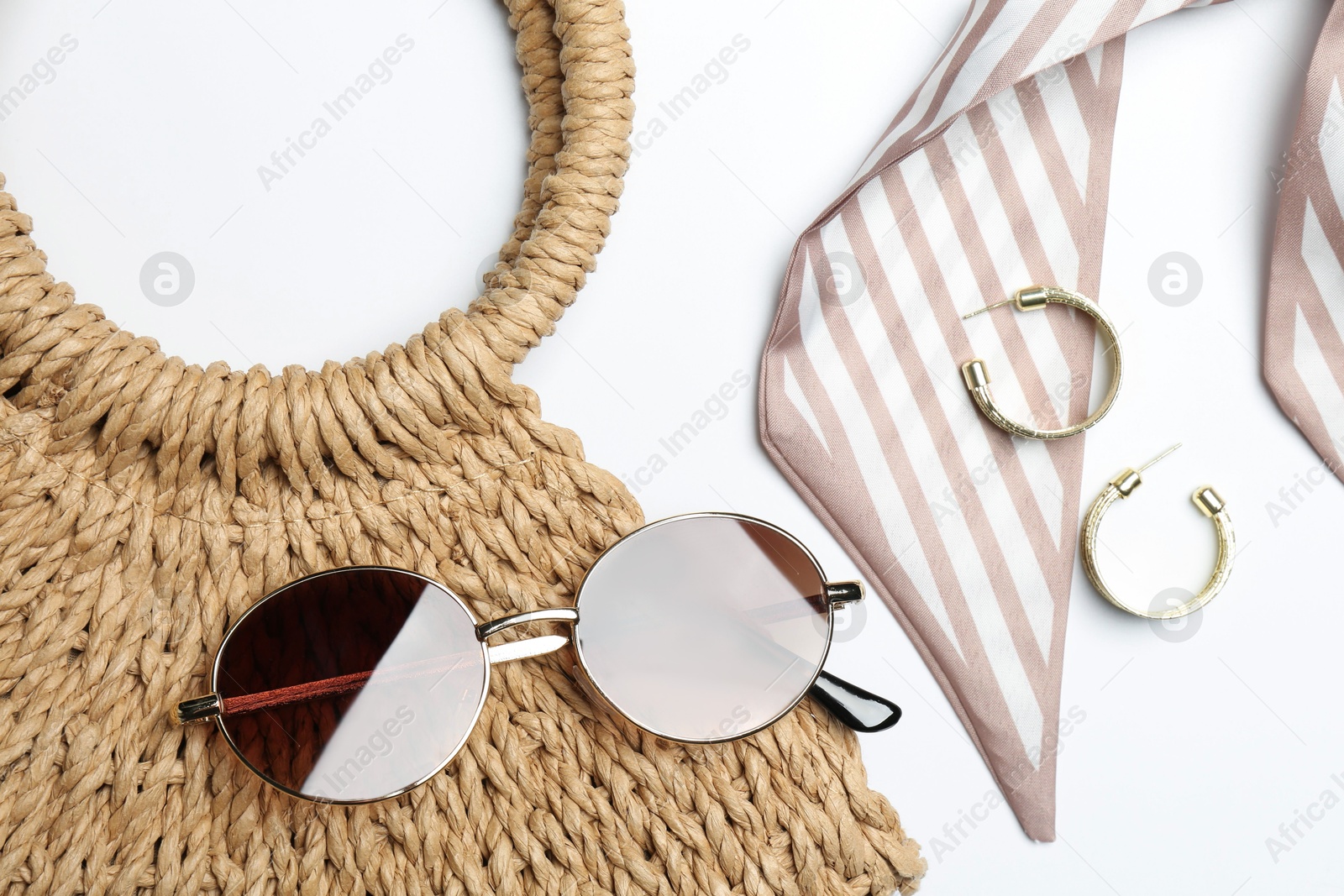 Photo of Wicker bag and stylish accessories on white background, flat lay