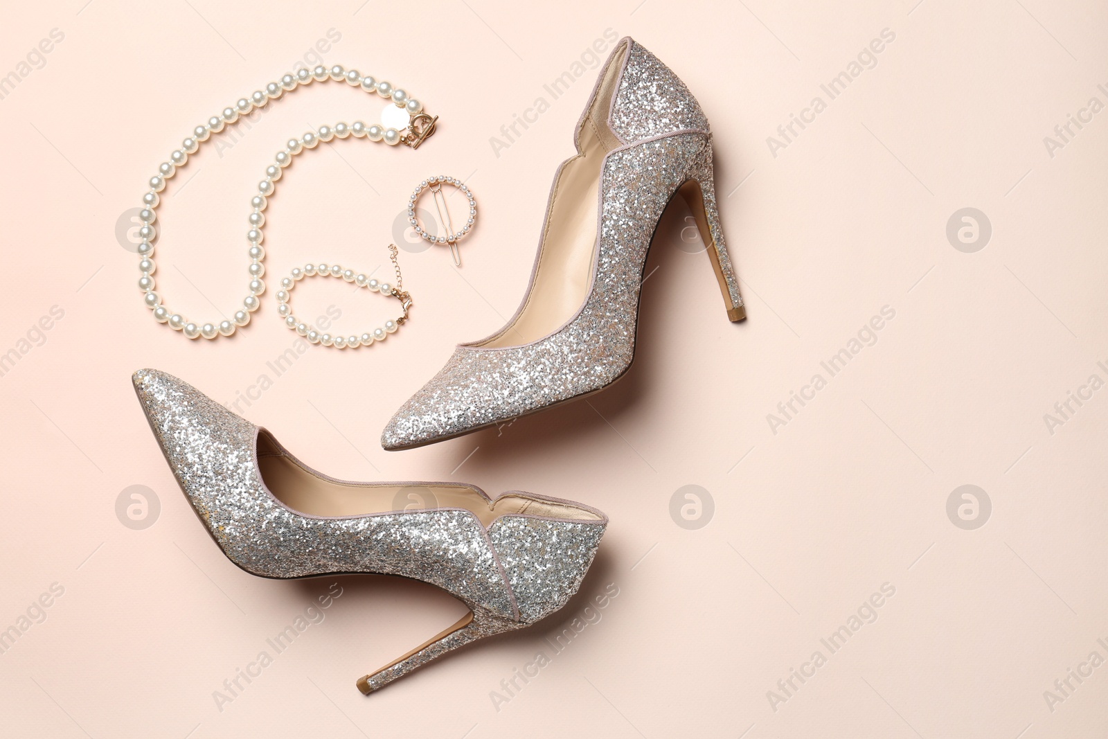 Photo of Stylish accessories and heels on beige background, flat lay