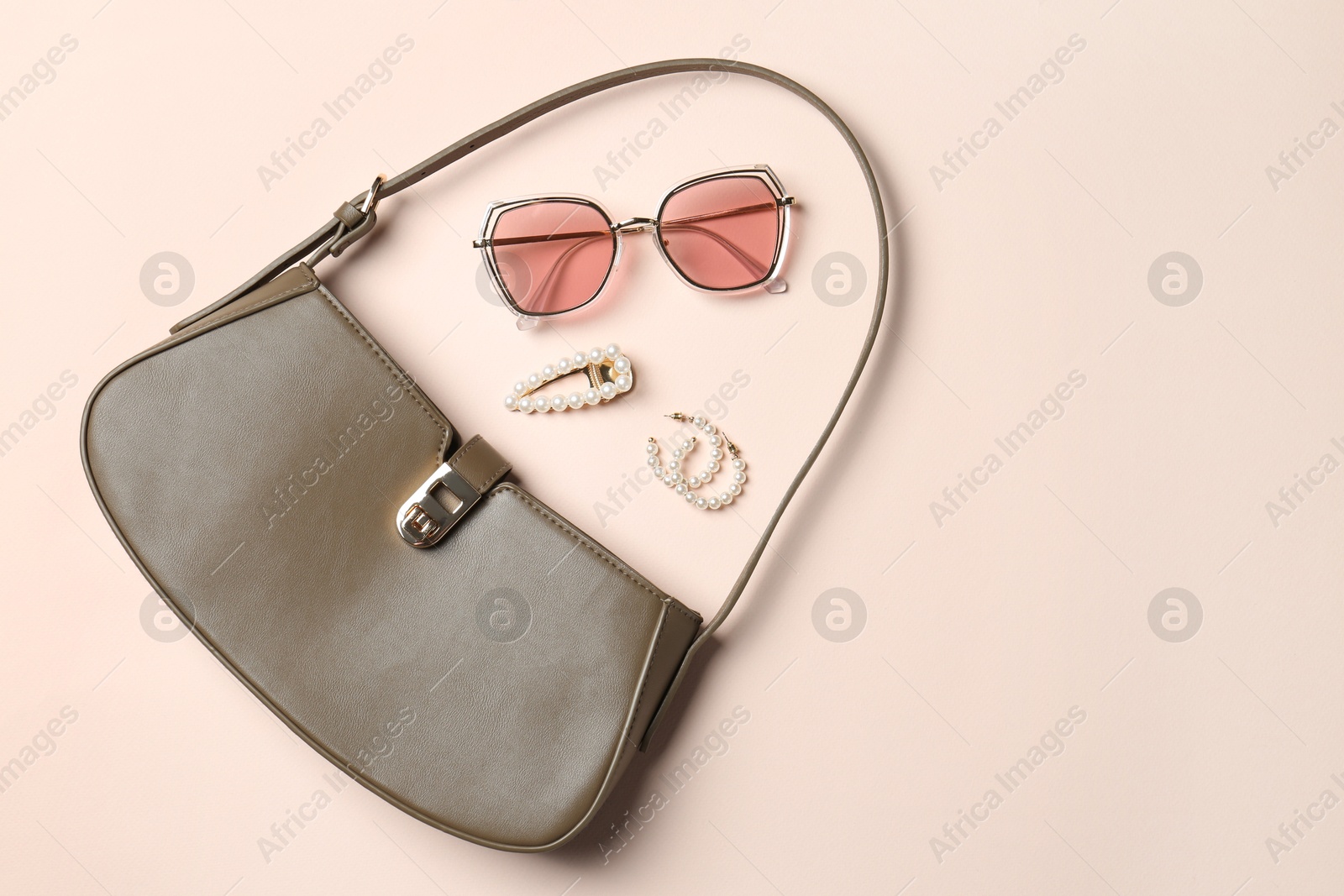 Photo of Beautiful bag and stylish accessories on beige background, flat lay