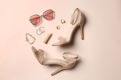 Photo of Stylish accessories and heels on beige background, flat lay