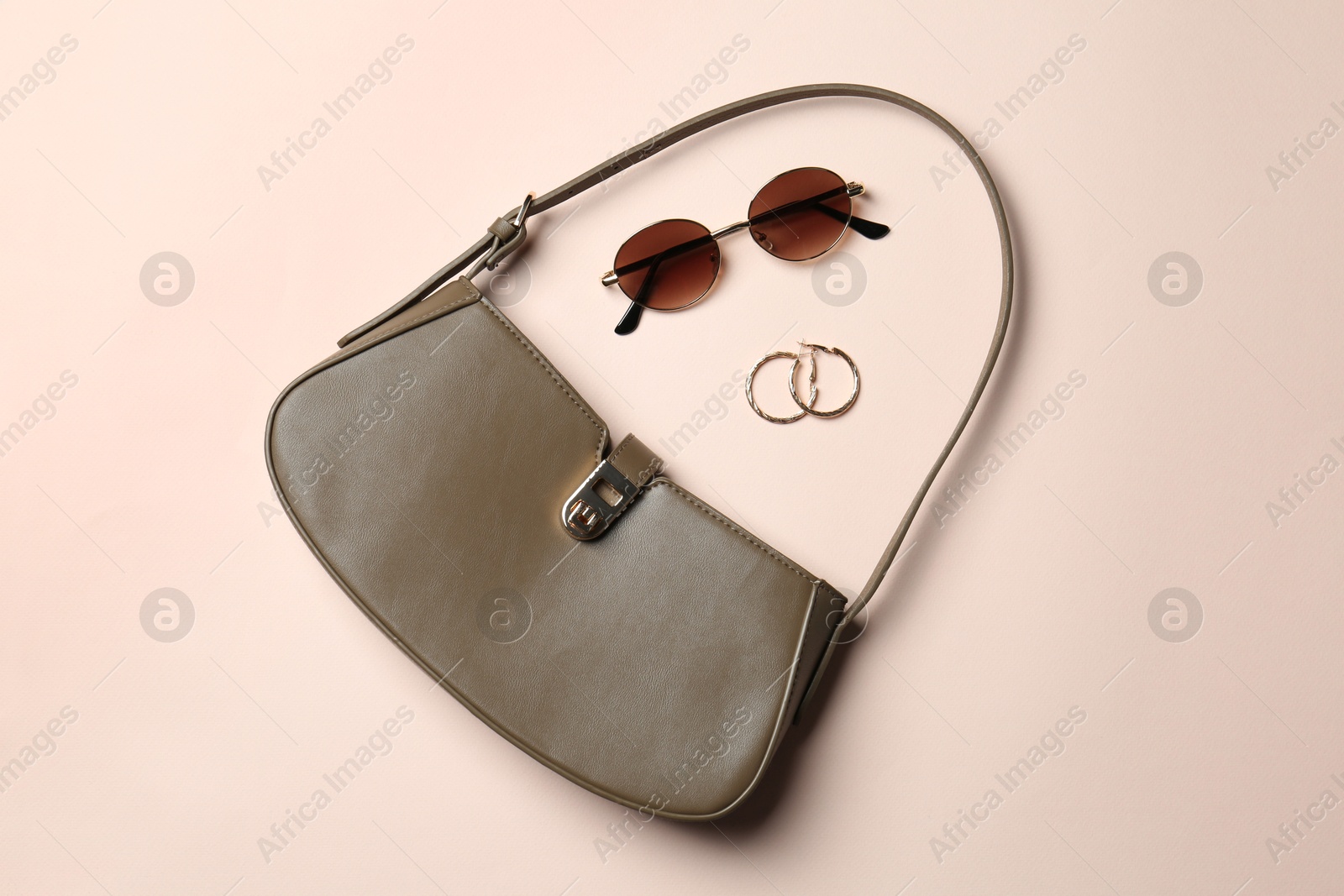 Photo of Beautiful bag and stylish accessories on beige background, flat lay