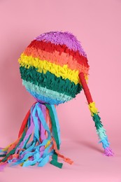 Photo of Colorful pinata and stick on pink background