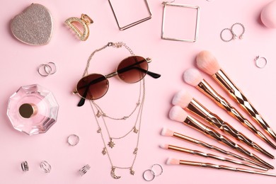 Photo of Stylish accessories and perfume on pink background, flat lay