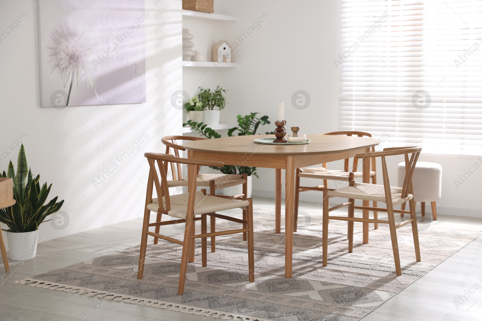 Photo of Stylish room with wooden table, chairs and houseplants. Interior design