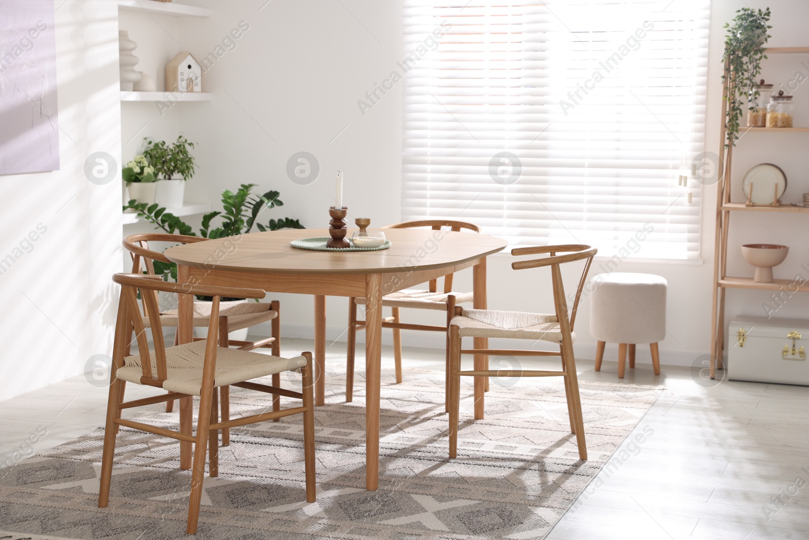 Photo of Stylish room with wooden table, chairs and houseplants. Interior design