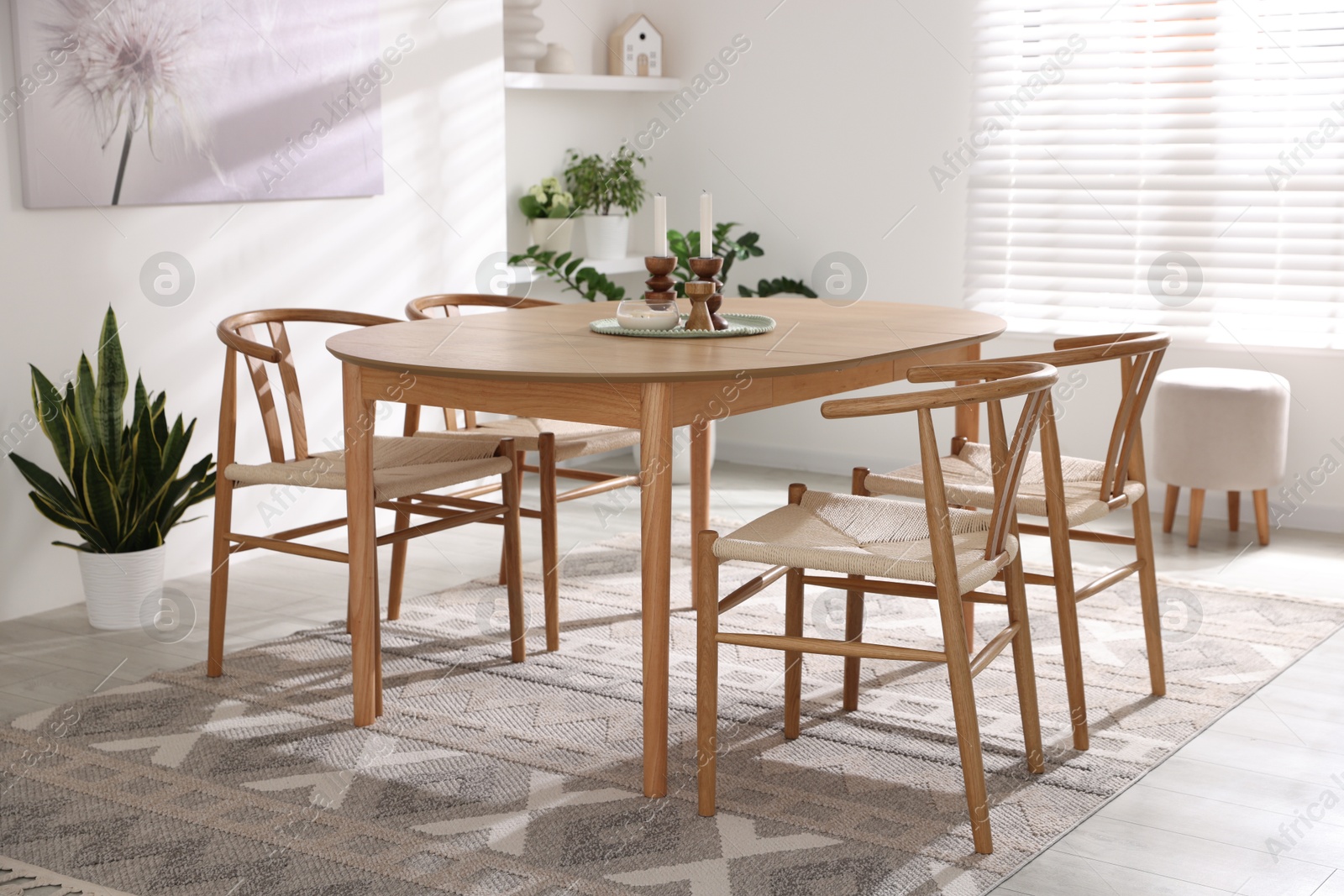 Photo of Stylish room with wooden table, chairs and houseplants. Interior design