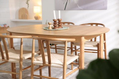 Photo of Wooden table with candles and chairs in room