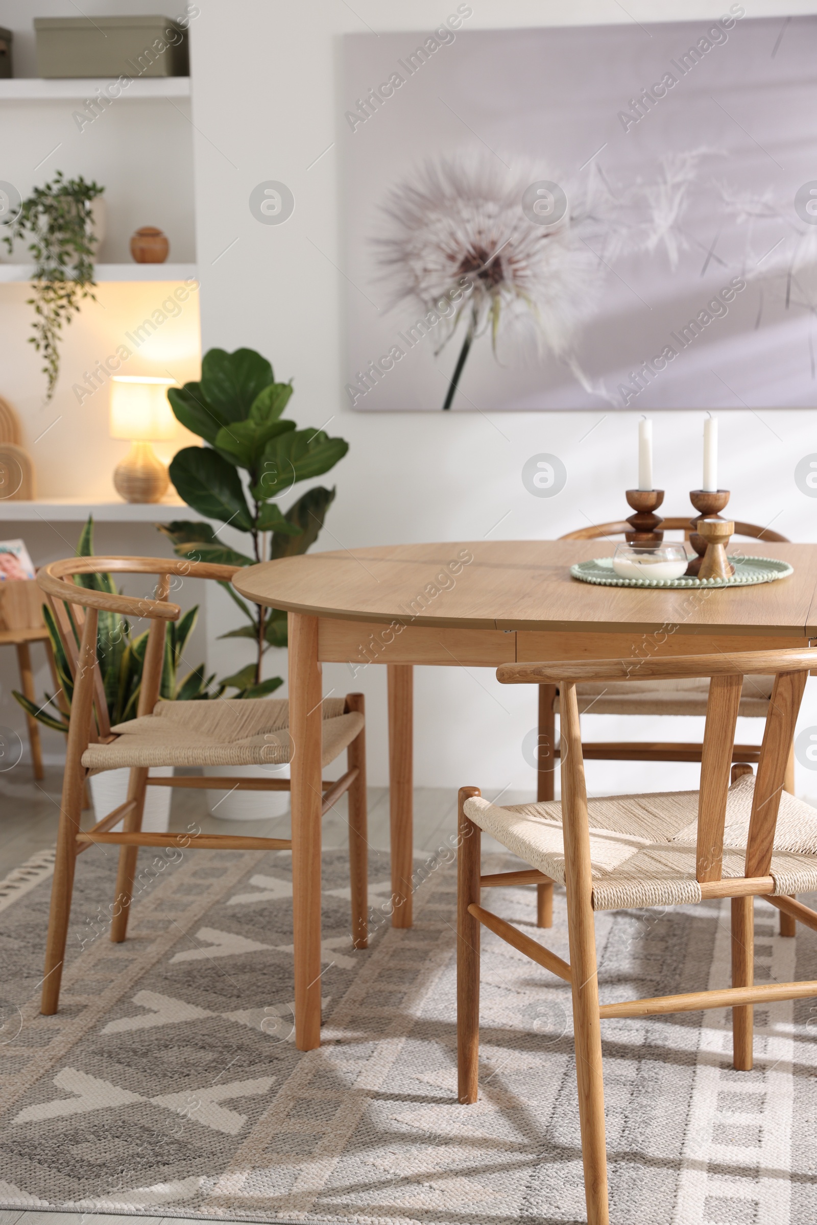 Photo of Stylish room with wooden table, chairs and houseplants. Interior design