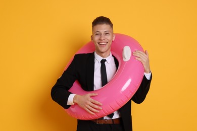 Photo of Businessman with inflatable ring on orange background