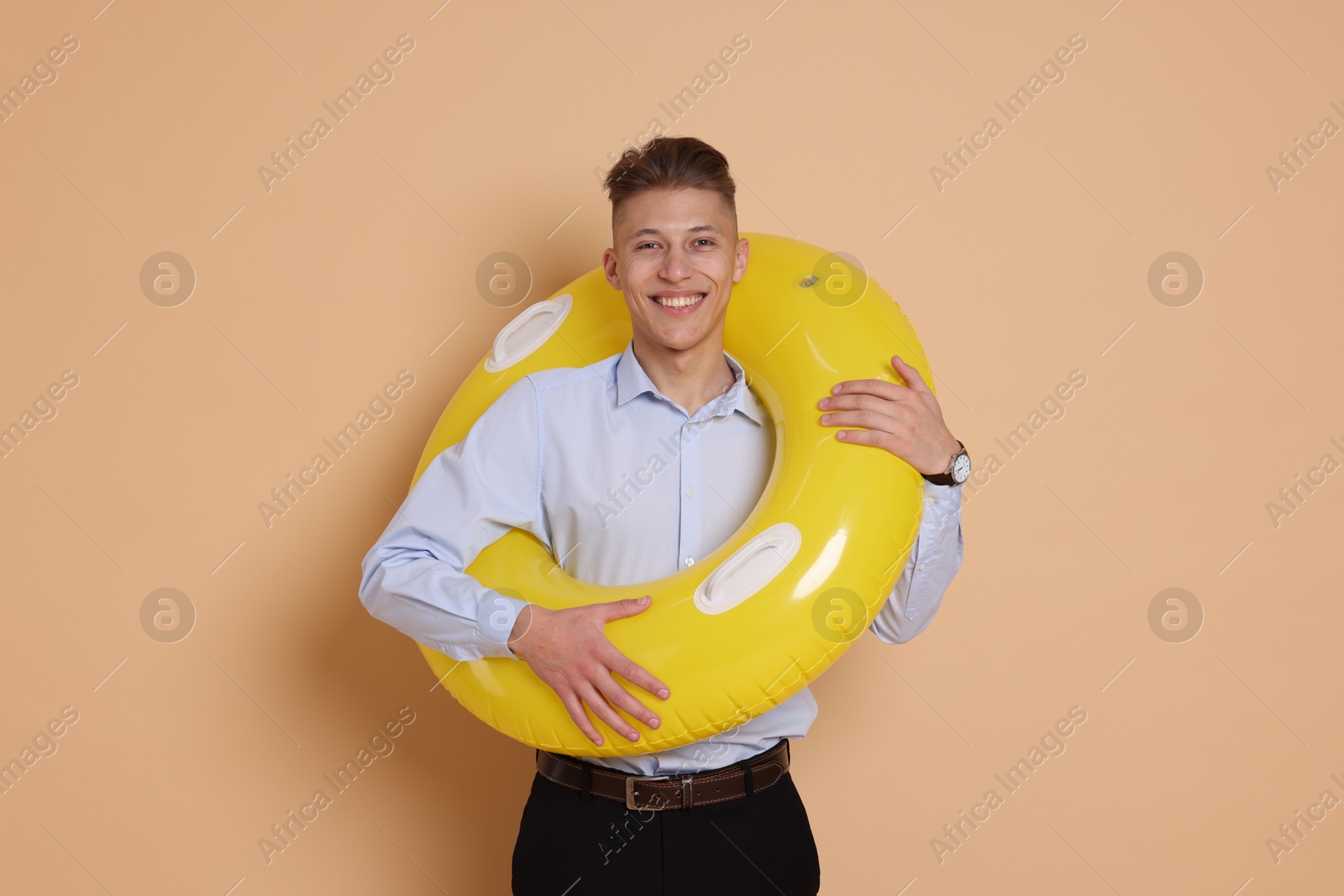 Photo of Businessman with inflatable ring on beige background