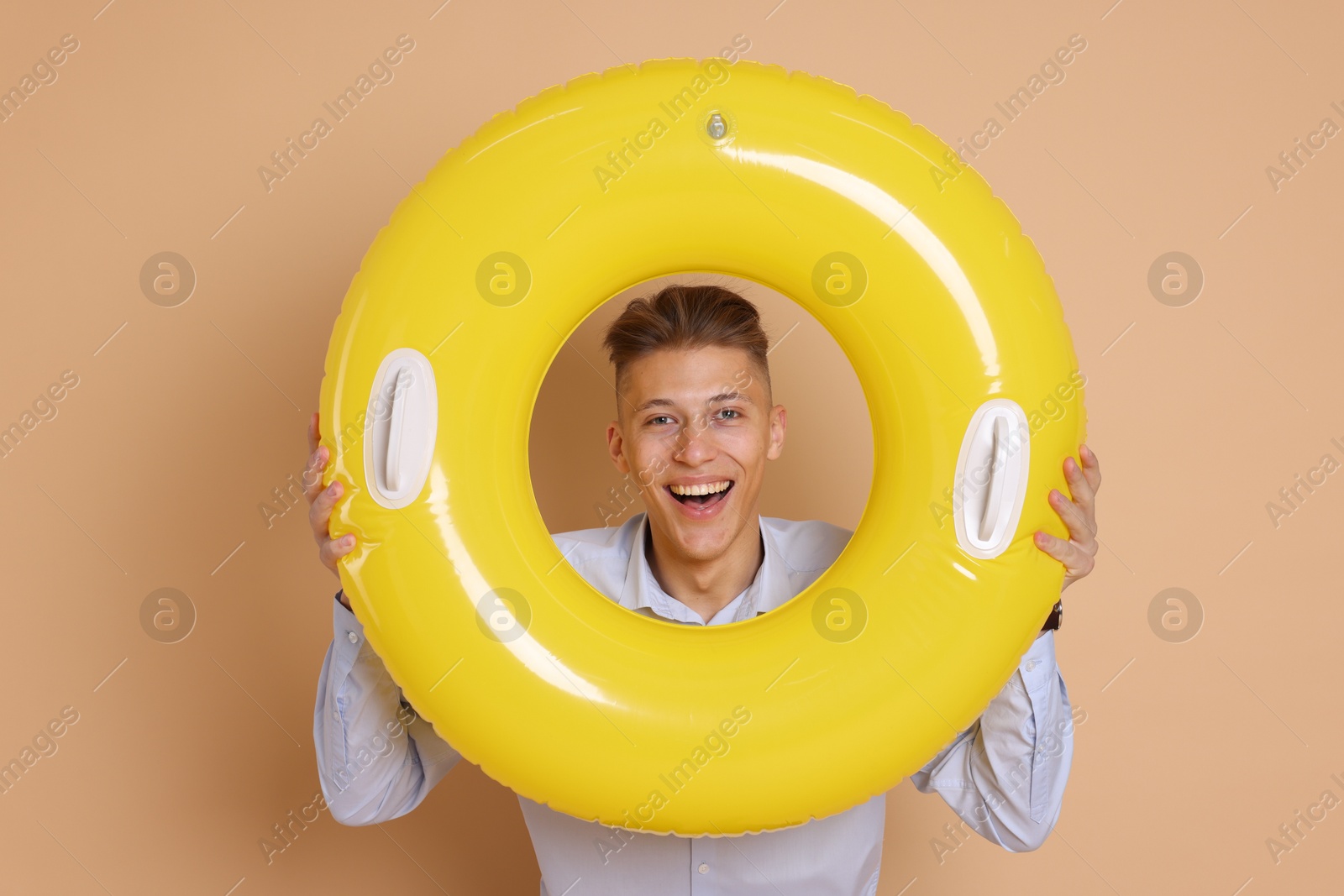 Photo of Businessman with inflatable ring on beige background