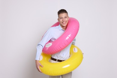 Photo of Businessman with inflatable rings on white background