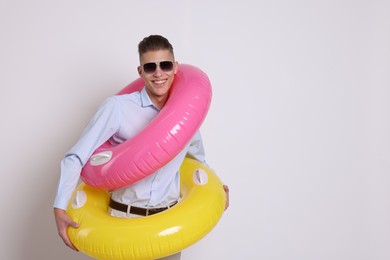 Photo of Businessman with inflatable rings on white background, space for text