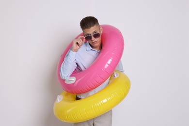 Photo of Businessman with inflatable rings on white background