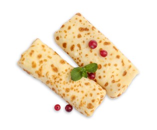 Photo of Delicious rolled crepes with cranberries and mint isolated on white, top view