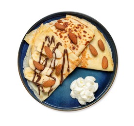 Photo of Delicious crepes with chocolate sauce, banana, almonds and whipped cream isolated on white, top view