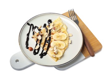 Photo of Delicious crepe with banana, nuts and chocolate sauce isolated on white, above view