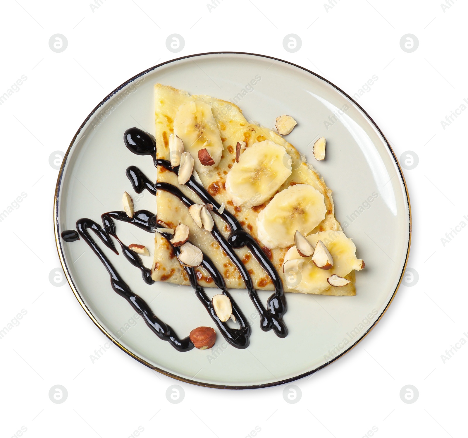 Photo of Delicious crepe with banana, nuts and chocolate sauce isolated on white, top view