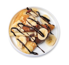 Delicious crepes with banana, nuts and chocolate sauce isolated on white, top view