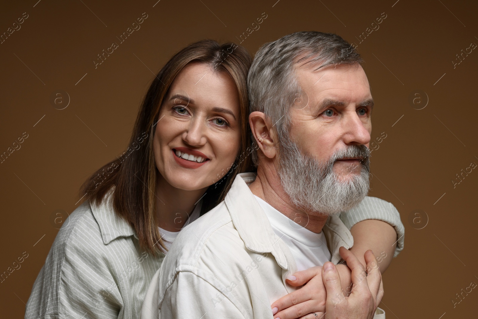 Photo of Happy daughter and her father on brown background