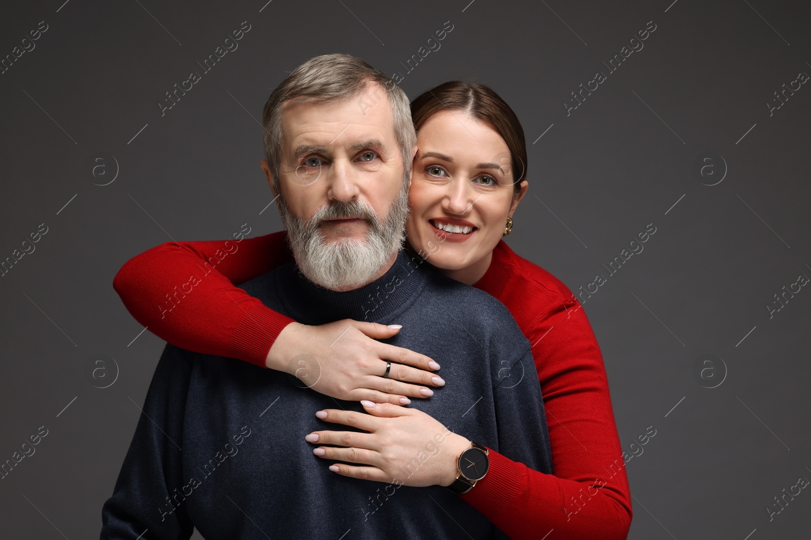 Photo of Family portrait of happy daughter hugging her father on dark background