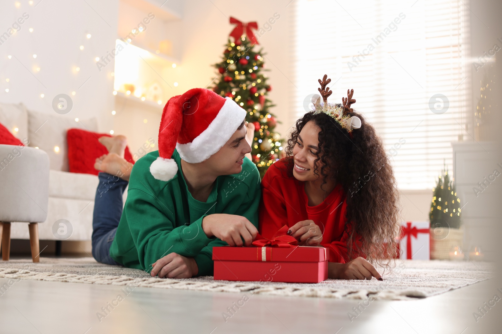 Photo of Happy couple with Christmas gift spending time together at home