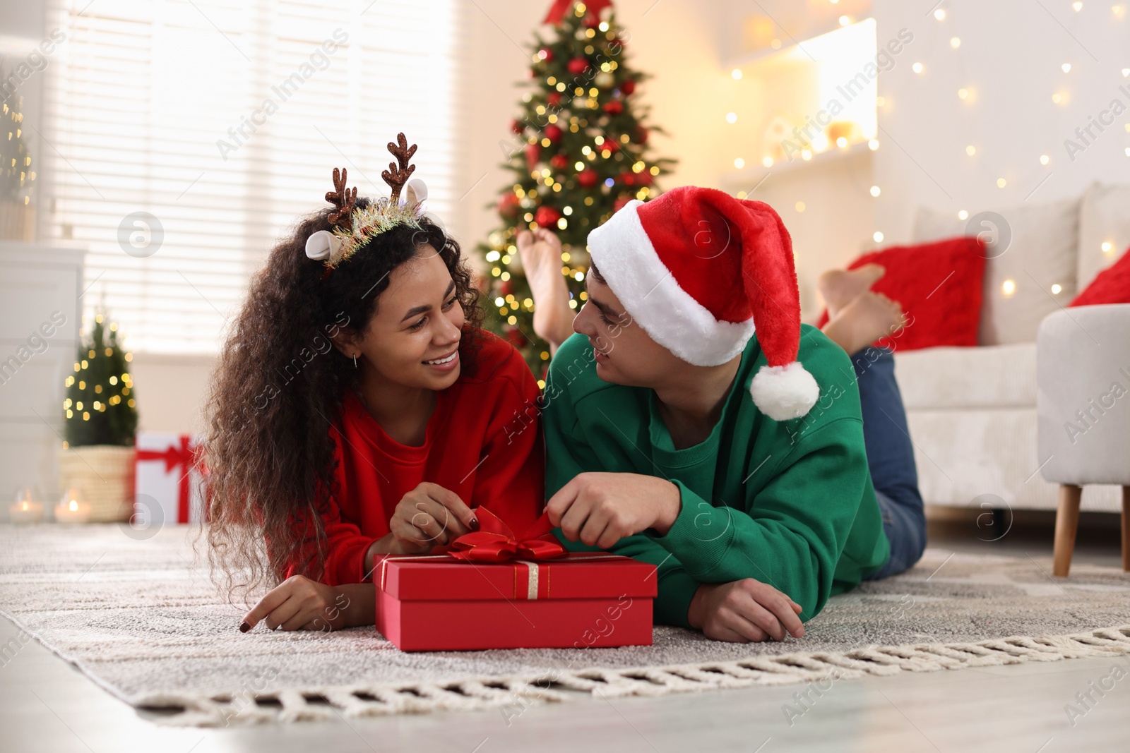 Photo of Happy couple with Christmas gift spending time together at home