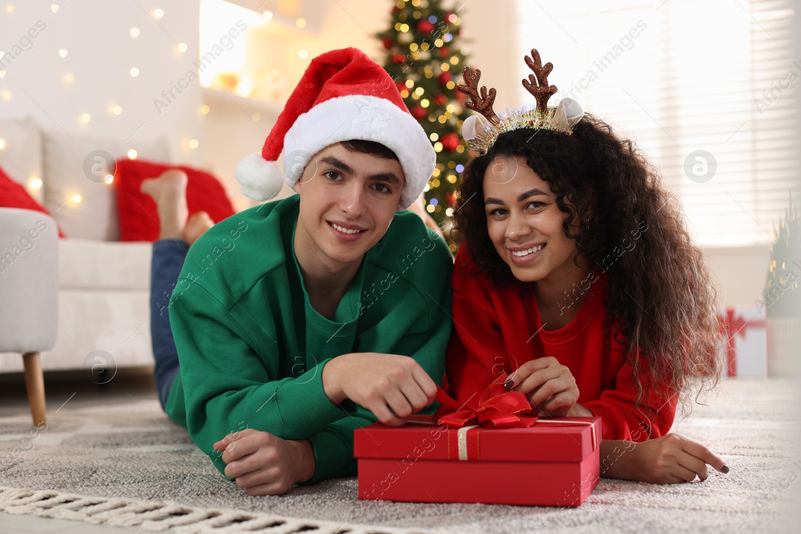 Photo of Happy couple with Christmas gift spending time together at home