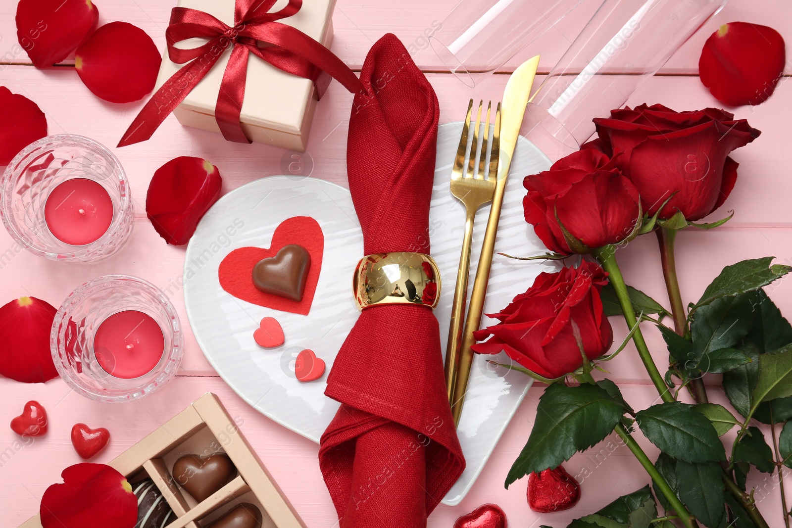 Photo of Flat lay composition with romantic place setting for Valentine's day on pink wooden table