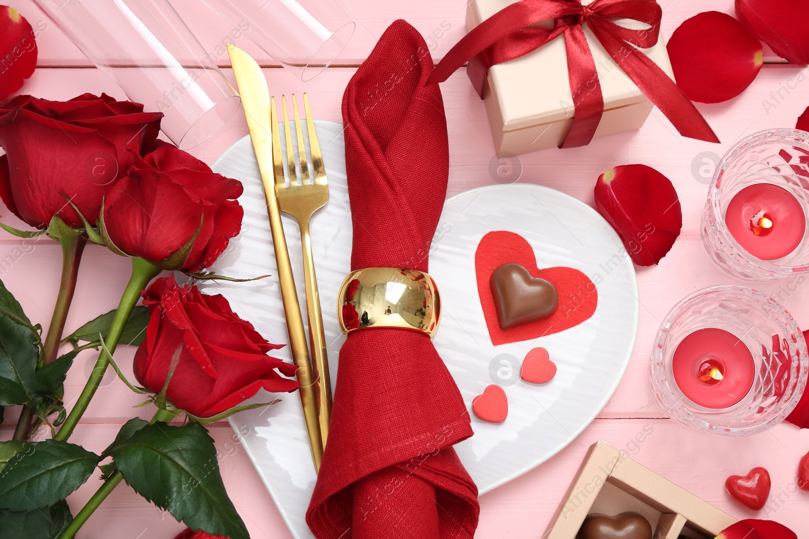 Photo of Flat lay composition with romantic place setting for Valentine's day on pink wooden table