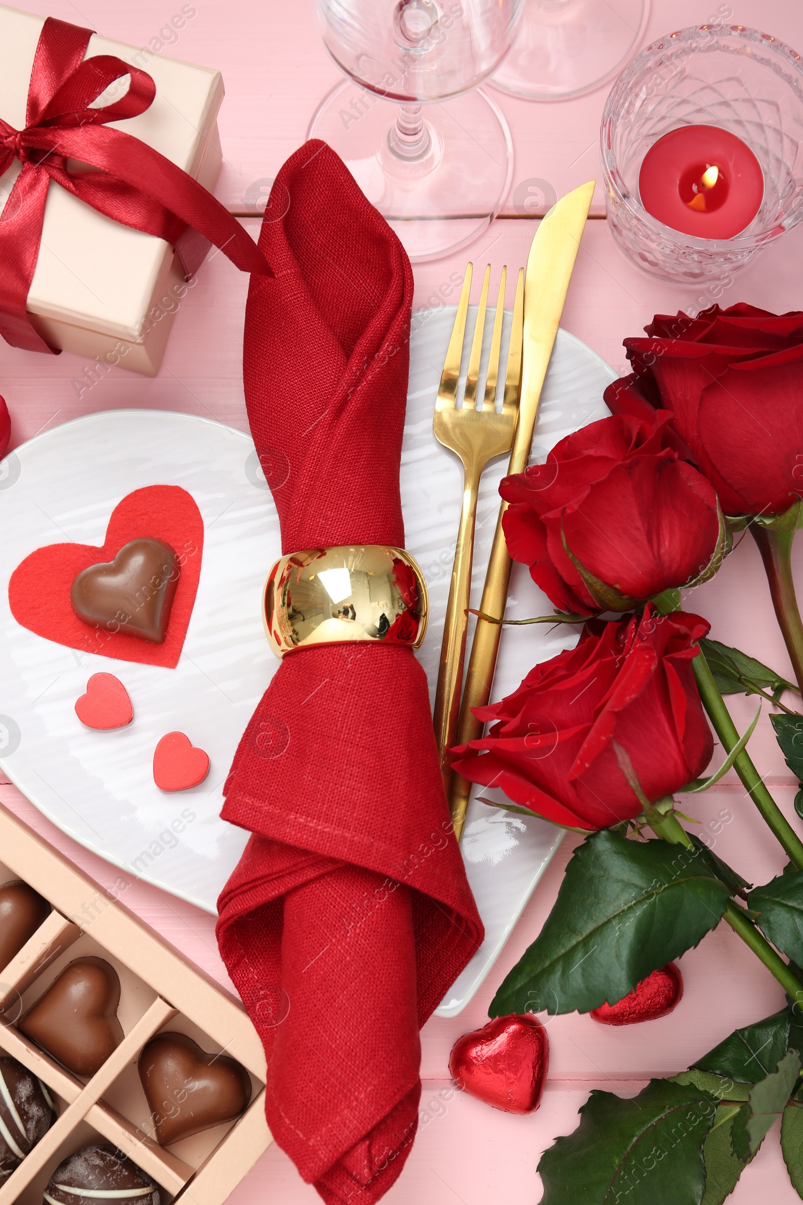 Photo of Flat lay composition with romantic place setting for Valentine's day on pink wooden table