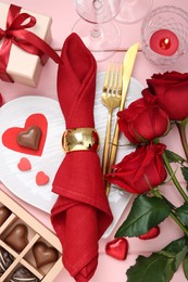 Photo of Flat lay composition with romantic place setting for Valentine's day on pink wooden table