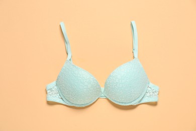 Photo of Beautiful turquoise bra on beige background, top view