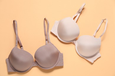 Photo of Beautiful bras on beige background, flat lay