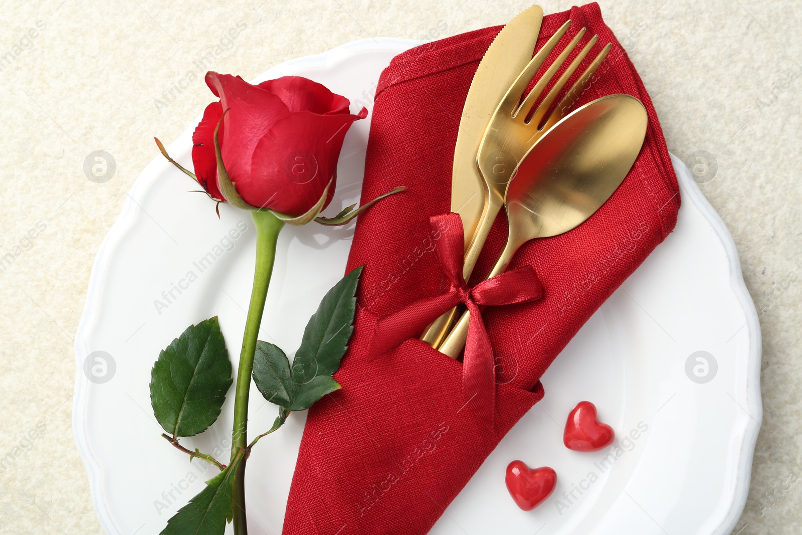 Photo of Romantic place setting with red rose on white table, top view. Valentine's day celebration