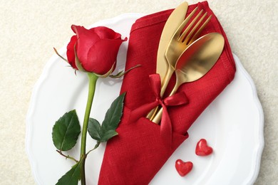 Photo of Romantic place setting with red rose on white table, top view. Valentine's day celebration