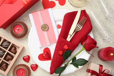 Photo of Romantic place setting with red rose on table, flat lay. Valentine's day celebration