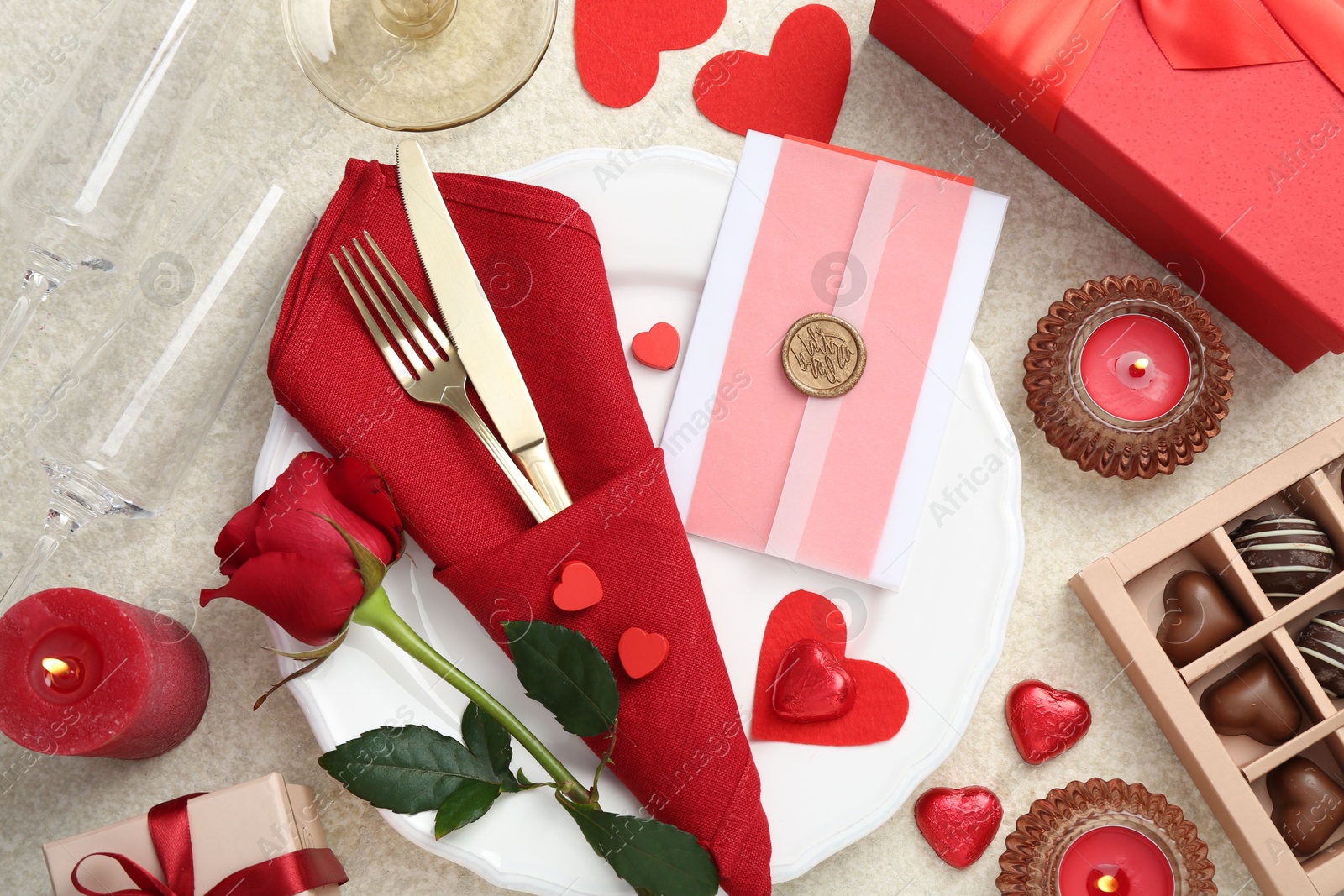 Photo of Romantic place setting with red rose on table, flat lay. Valentine's day celebration