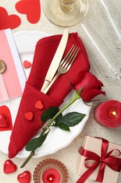 Photo of Romantic place setting with red rose on table, flat lay. Valentine's day celebration