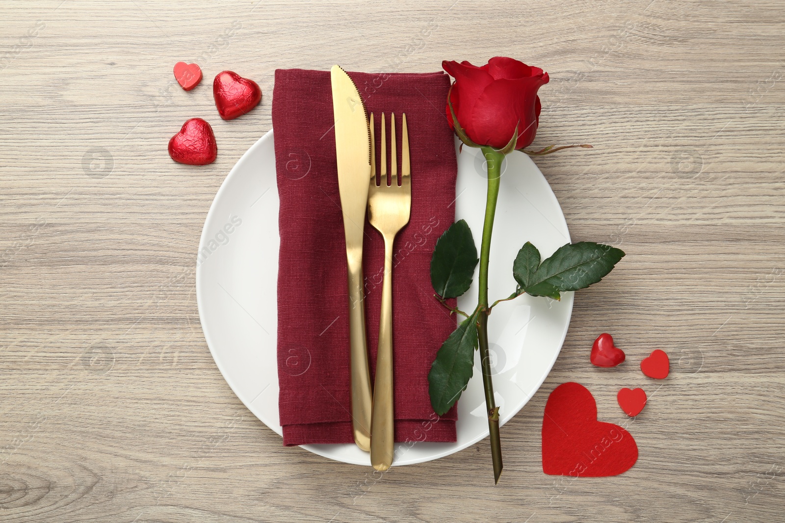 Photo of Romantic place setting with red rose on wooden table, top view. Valentine's day celebration