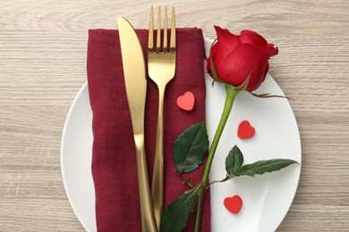 Photo of Romantic place setting with red rose on wooden table, top view. Valentine's day celebration