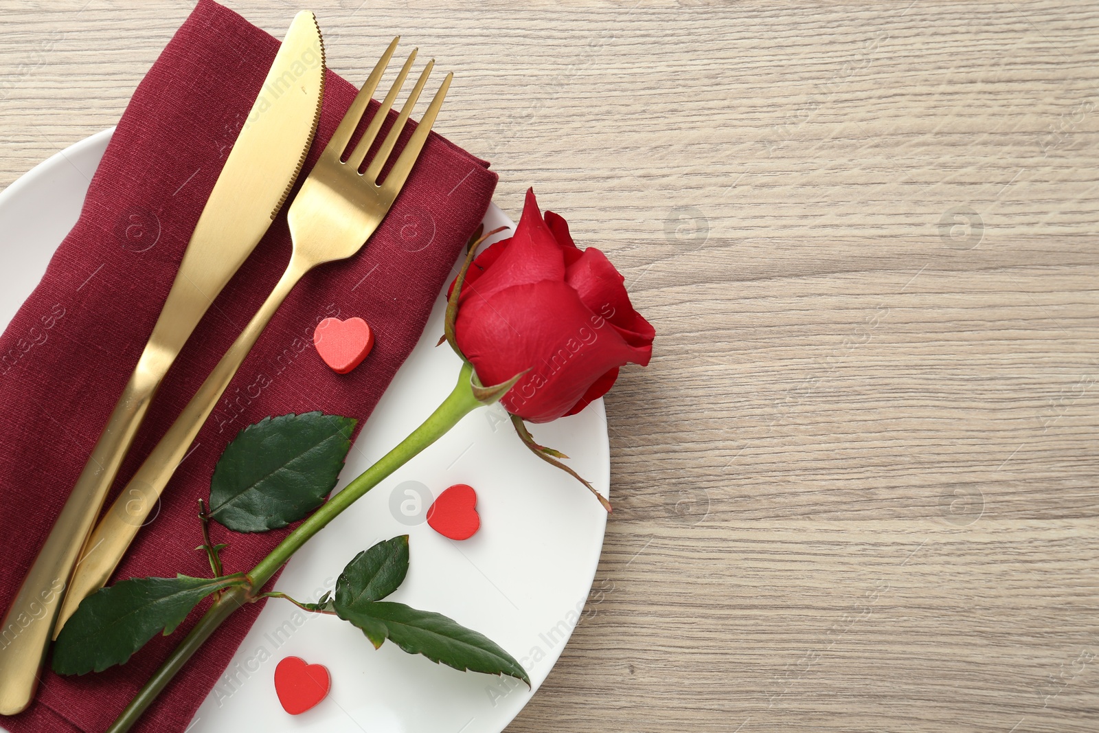 Photo of Romantic place setting with red rose on wooden table, top view. Valentine's day celebration